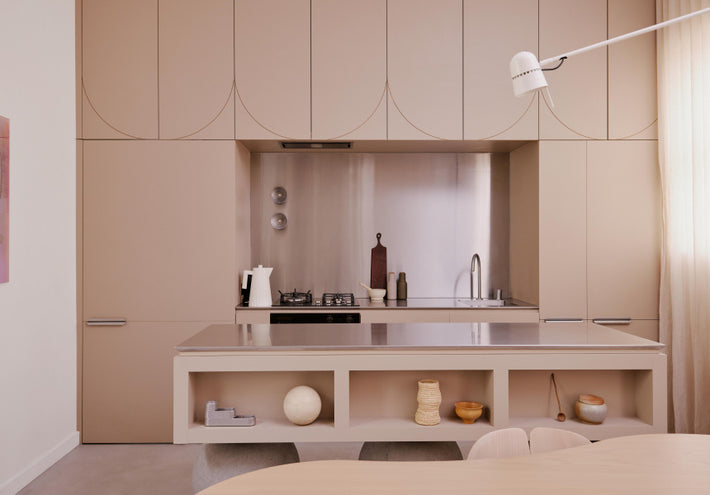 Wide angle image of kitchen at Hazel House featured project by Nat Turnbull. Muted salmon colour cabinets integrated with Titan stainless steel kitchen sink and Titan stainless steel kitchen tap.