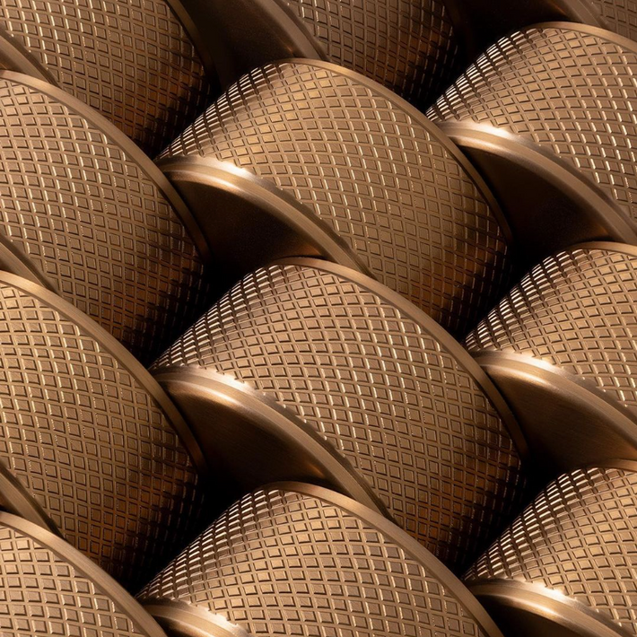 Close-up of Titan textured brass kitchen tap handles arranged in a repeating pattern, showcasing the intricate design and finish of the brass components.